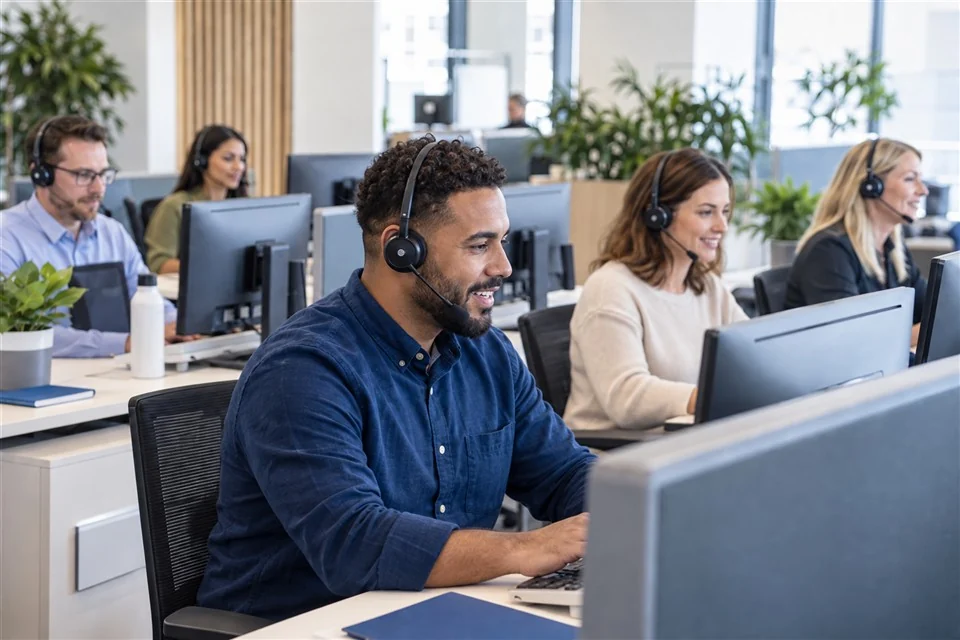 Illustrative call centre team with several agents handling customer calls using headsets